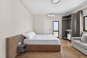 Ein modernes Schlafzimmer mit einem Bett, einer eingebauten Sitzbank, einem Kleiderschrank und einem Fenster.