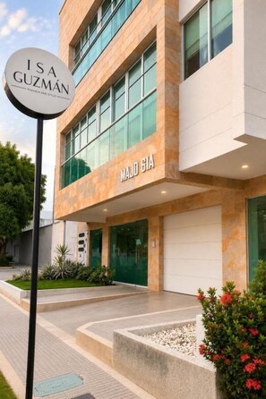 Un edificio moderno con un cartel que muestra 'ISA GUZMAN' y 'MAJO GIA' en la fachada.