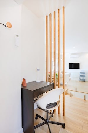 Ein moderner Arbeitsraum mit Schreibtisch, Stuhl und einer Holzwand.