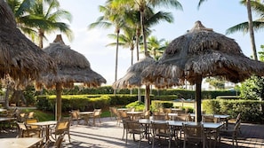 Ein Resort mit Reetdachschirmen und Sitzgelegenheiten im Freien.