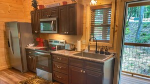 A kitchen with wooden cabinets, a stainless steel refrigerator, a microwave, a toaster, and a sink. - NEW LISTING~Quiet~cozy~clean~fast WIFI, Dollywood, hotub/FP #9 (Sevierville)