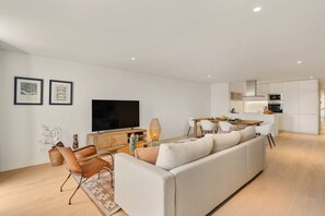 Ett modernt vardagsrum med en soffa, en tv och en matplats.