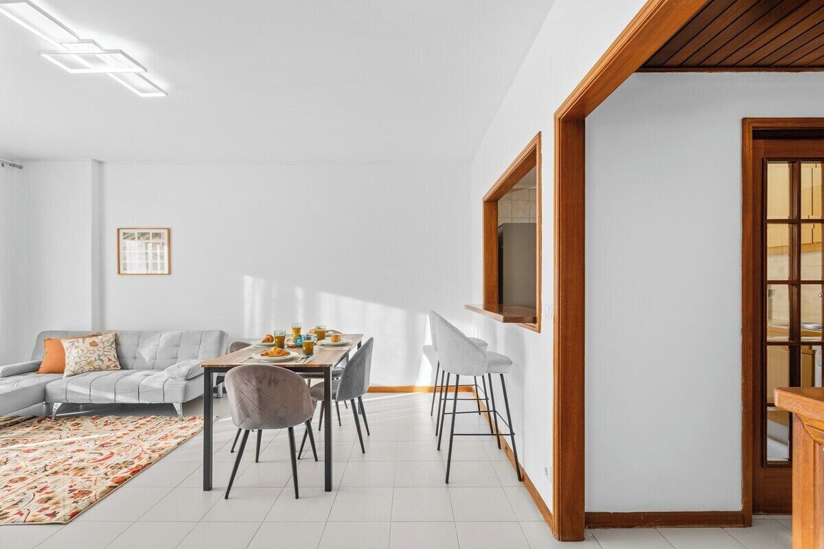 A modern living room with a dining table, sofa, and chairs.