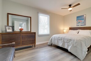 Ein Schlafzimmer mit Bett, Kommode und Deckenventilator.
