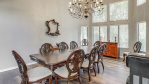 A dining room with a large wooden table, matching chairs, a chandelier, and a decorative mirror on the wall. - Pool, Spa: Updated Indian Palms Golf Retreat (Indio)