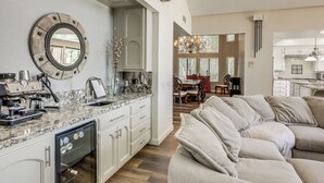 A modern kitchen with a dishwasher, a coffee machine, and a dining area with a chandelier. - Pool, Spa: Updated Indian Palms Golf Retreat (Indio)