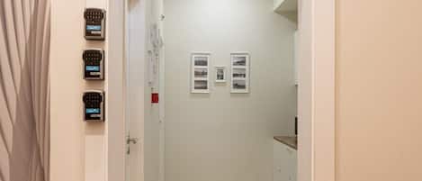A hallway with wooden flooring, a white door, and a small table with a wooden top.