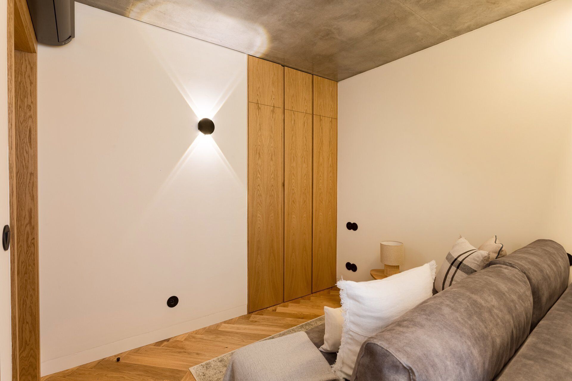 Un intérieur moderne avec une armoire en bois, un canapé et une lampe.