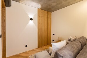 Een modern interieur met een houten garderobe, een bank en een lamp.