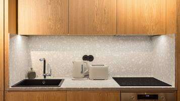 A kitchen with wooden cabinets, a granite countertop, a sink, a toaster, and an oven.