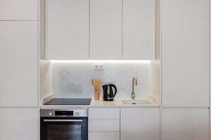 A compact kitchen with a built-in oven, a coffee maker, and a sink. - The Morning Light @ BoaVista Flats (Porto)