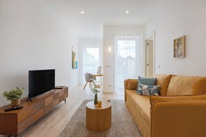 A living room with a TV, sofa, and coffee table. - The Morning Light @ BoaVista Flats (Porto)