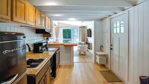 Une cuisine dotée de meubles en bois, d’un réfrigérateur en acier inoxydable, d’un plan de travail et donnant sur un balcon.