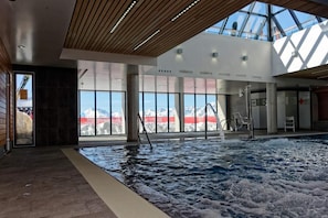 An indoor swimming pool with a view of mountains, wooden ceiling, and large windows. - 100m from ski slopes, 2nd floor, jacuzzi, hammam, terrace, parking, tv, ski locker, 51m², Peyragudes (Germ)