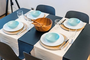 Ein Tisch gedeckt mit blauen Schüsseln, Holzlöffeln und klaren Gläsern.