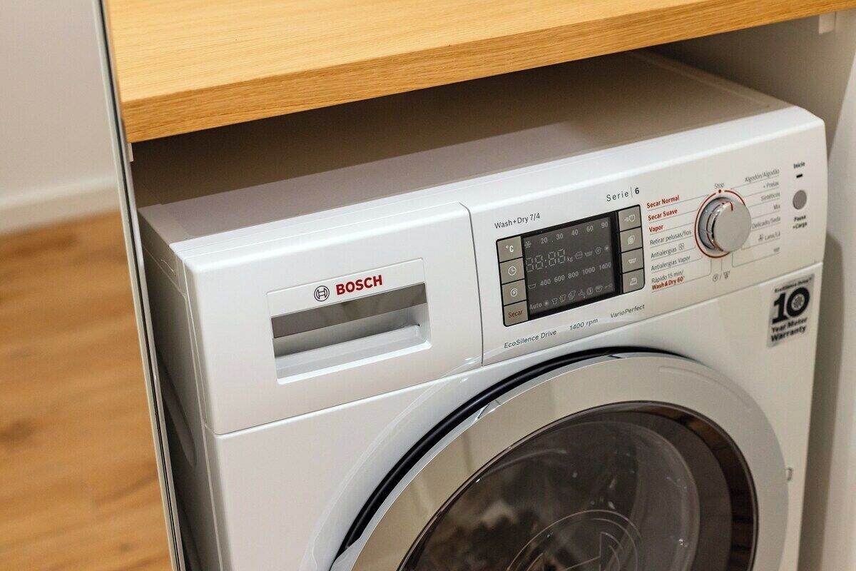 Una lavadora Bosch con pantalla digital, una perilla de control y una etiqueta que indica una garantía de 10 años.