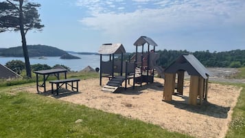 A playground with a slide, climbing structures, and a picnic table.