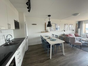 Una cocina moderna con comedor, sofá y vistas al exterior.