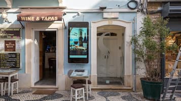 Un ristorante di vino e tapas con una lavagna dei menu, posti a sedere all'aperto e una porta con il numero 293.