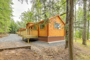 Eine Holzhütte mit einer Terrasse, umgeben von Bäumen.