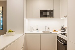 Ett modernt kök med en mikrovågsugn från Bosch, en diskho, en kaffemaskin och en diskmaskin.
