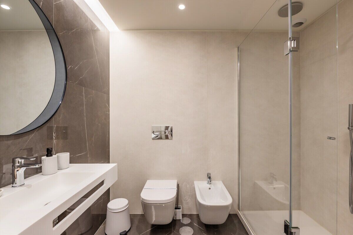A modern bathroom with a toilet, bidet, and shower.