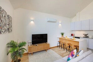A modern apartment with a living room, kitchen, and bar area. - Duque de Saldanha Duplex Loft (Porto)