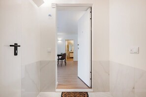 Un pasillo que conduce a un comedor con mesa y sillas.