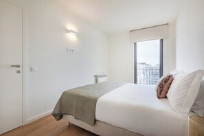 Un dormitorio con cama, ventana con vistas, radiador y puerta.