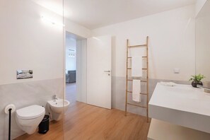 Ein modernes Badezimmer mit Toilette, Bidet und Waschbecken.