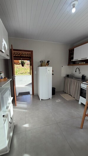 A compact kitchen with a refrigerator, sink, and stove. - Vale Refuge Azul | 3-bedroom house complete with stone hot tub Azul (Aracê)