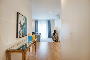 A modern living room with a glass coffee table, a sofa, a TV, and a lamp. - Paraíso Porto Living (Porto)