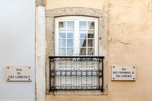 Eine Gebäudefassade mit einem Fenster und zwei Straßenschildern, die Rua de São Lourenço anzeigen.