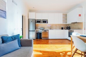 A compact kitchen with white cabinets, a stainless steel refrigerator, and a dishwasher. - Suite Standard @ Guest Inn 1 Boutique House (campo pequeno)