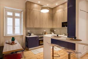 Una cocina moderna con armarios de madera, horno empotrado y una ventana.
