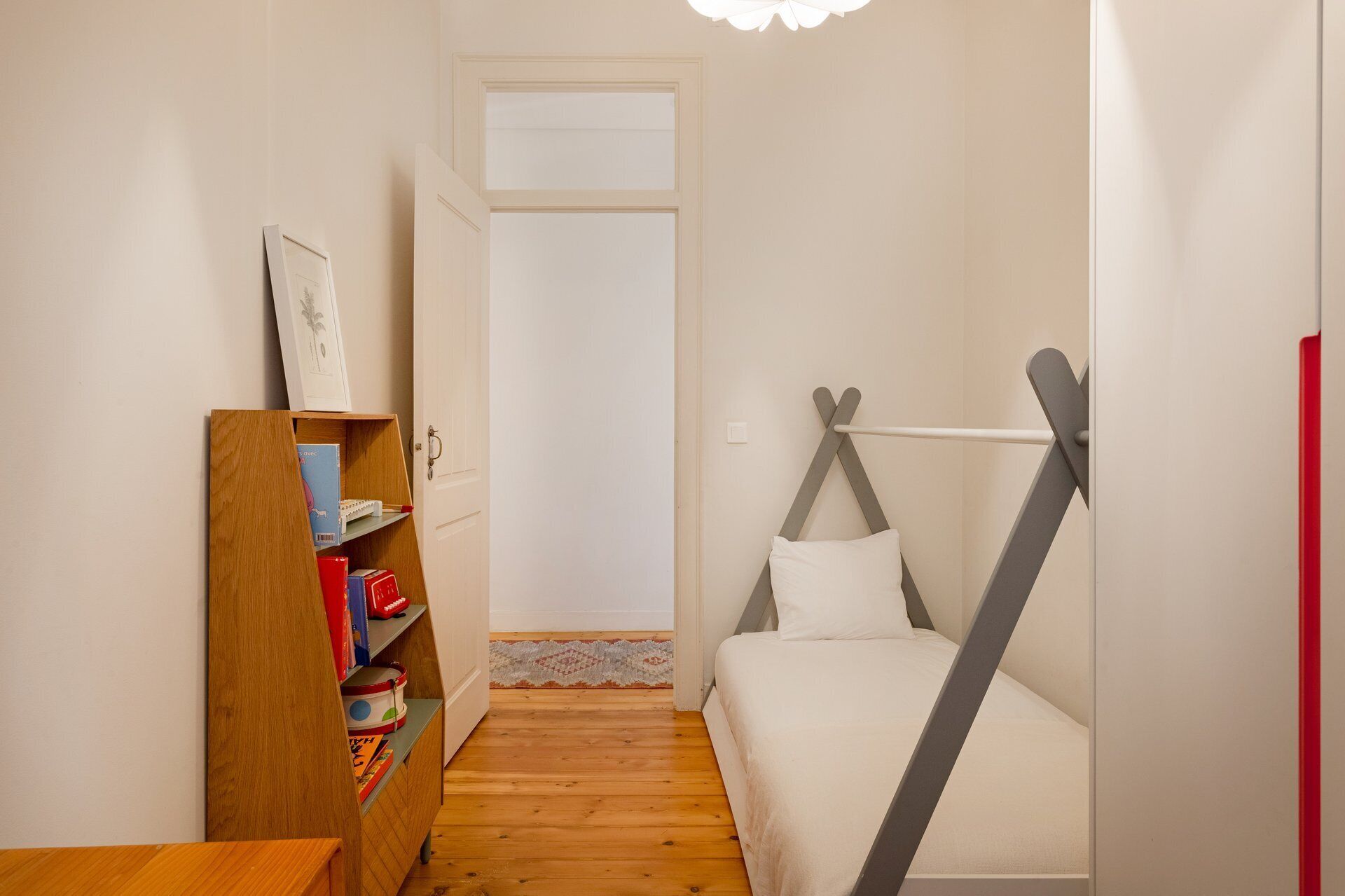 Ein Schlafzimmer mit einem Bett, einer Holzregal und einer Tür zu einem anderen Raum.