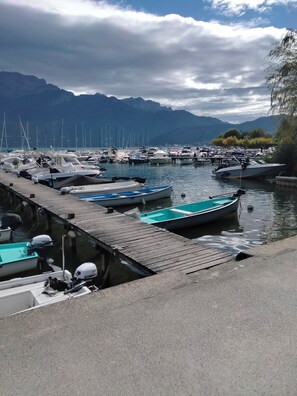 Ein Yachthafen mit vertäuten Booten, eine Holzsteganlage und Berge im Hintergrund.