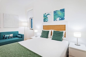 A hotel room with a bed, a sofa, a nightstand, and wall art. - Double Room @ Guest Inn 2 Boutique House (campo pequeno)