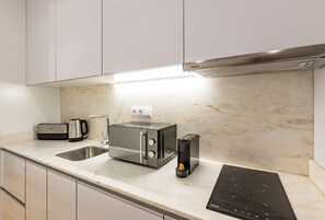 Eine moderne Küche mit eingebautem Toaster, einer Kaffeemaschine und einer Induktionskochplatte.