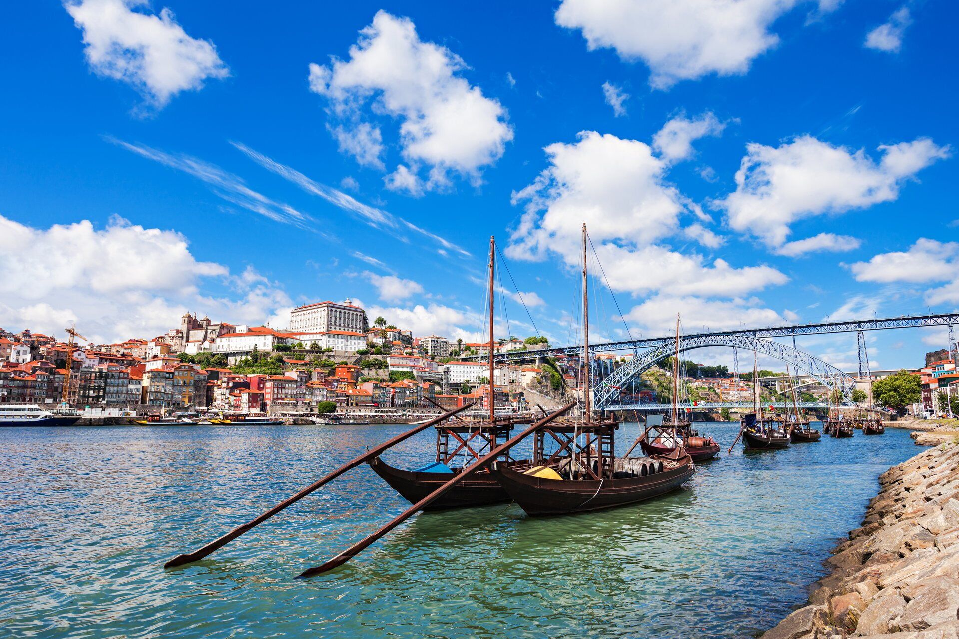 A river with boats, a bridge, and buildings in the background.