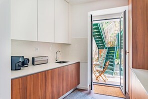 Een moderne keuken met houten kastjes, een ingebouwde koffiezetapparaat en een spoelbak.