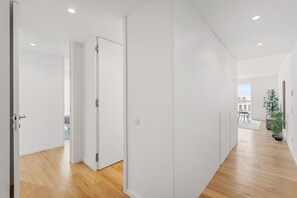 Ein modernes Interieur mit Holzboden, weißen Wänden und Blick ins Freie.