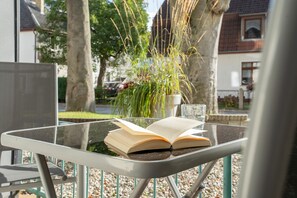 Una mesa de vidrio con un libro abierto y un vaso de agua.