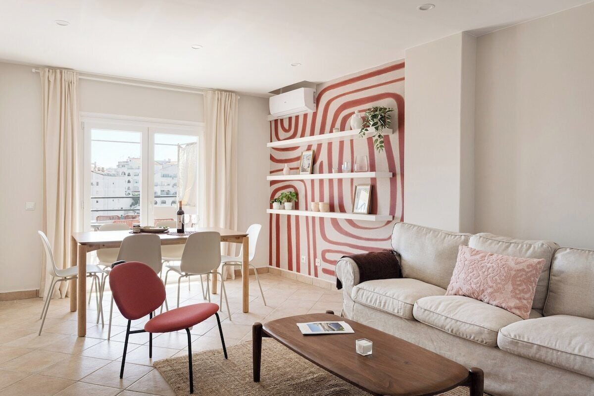 A modern living room with a sofa, coffee table, and dining area.