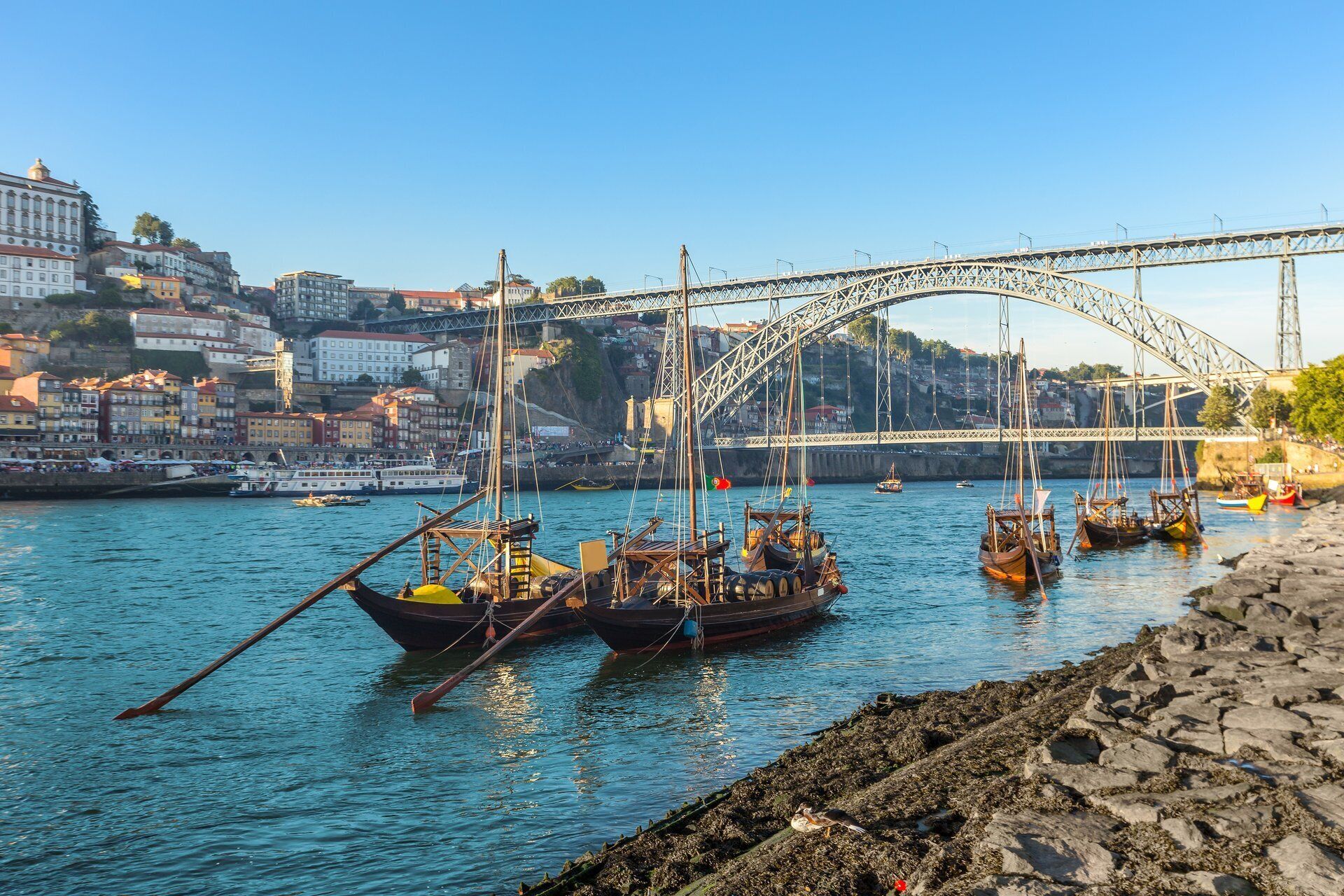 A harbor with boats, a bridge, and buildings in the background.
