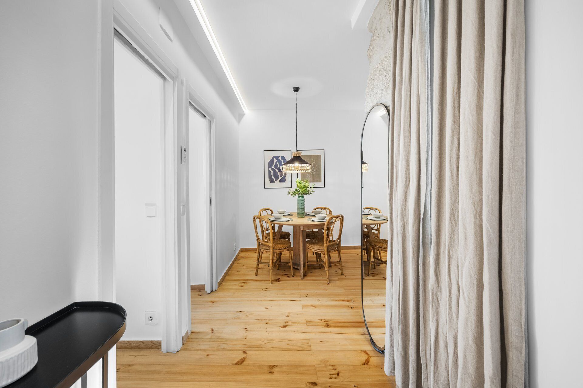 En hall med en matplats som har ett runt bord, stolar och en hängande lampa.