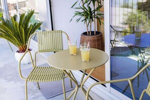 Une table avec deux boissons, une chaise et un pot de fleurs.