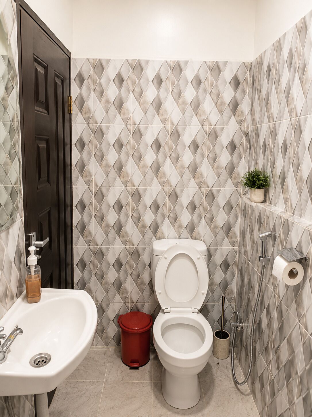 Une salle de bain avec des toilettes, un lavabo et une douche.