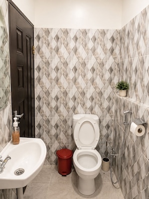 A bathroom with a toilet, sink, and shower.