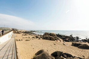 A beach with a rocky shoreline, a walkway, and the ocean in the background. - Gaia Elegant Retreat I (Canidelo)
